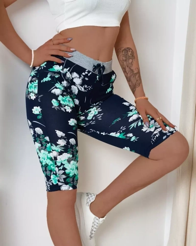 Dámske 3/4 tmavomodré kraťasy so zelenými kvetmi PLUS SIZE - Oblečenie